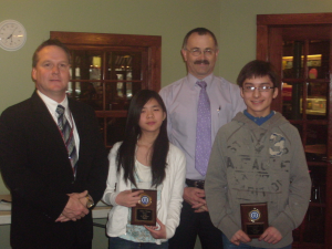 Oskaloosa seventh grade students Sihan Chang and Efrain Garcia, Jr., were honored by the Oskaloosa Optimist Club on Wednesday. Presenting the plaques were Oskaloosa Middle School Principal Andy Hotek, left, and club president Keith Comfort.