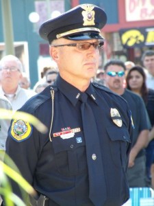 Oskaloosa Police Chief John "Jake" McGee stands at parade rest during the service to remember 9/11