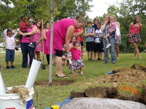Holly's mother Candy and her daughter help plant a tree in Holly's memory on Saturday.