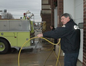 Oskaloosa Firefighter Scott Howard and Captain Tim Nance clean equipment after an early morning fire Monday