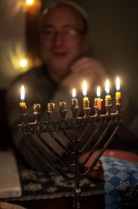 Rick Vogel sits behind the menorah one evening during Hanukkah.