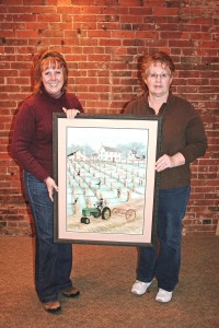 Mahaska Hospice Auxiliary President Diane Davis presents the P. Buckley Moss print to Jan Boender of Oskaloosa. Boender won the print in a raffle fundraiser, which raised $1,740 for patients of Mahaska Health Partnership Hospice Services. (submitted photo)