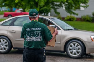 This Mahaska County Cert Member walks a case of water out to an elderly individual during their water distribution efforts.