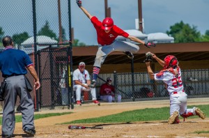 This Missouri player takes to the air in an attempt to avoid the catcher during the Midwest Plains Regional Senior Babe Ruth Tournament in Oskaloosa, Iowa.