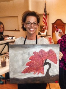 Michelle Purdum hold her recent creation at a Wine & Canvas event. (submitted photo)