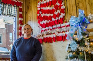 Julie Wells stands next to just some of the stockings that represent those who made donations to help feed those less fortunate. 