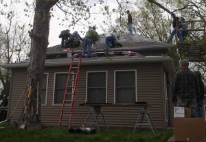 Family and friends come together to put a new roof on Cole Nilson's home Saturday. (photo by Brenda Doty Aschinger)