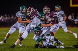 Bennett Spry is brought down by a a group of Pella Dutch on Friday night at the Lacey Stadium.