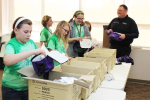 The Girl Scouts Troop 746, consisting of 5th graders from Oskaloosa Elementary School, recently received their First-Aid badges. They were assisted in their quest by Mahaska Health Partnership and MHP Paramedic Jamey Robinson, who also serves as Director of Mahaska County Emergency Management Agency. The girls had to build a first-aid kit, tour an emergency department and ambulance, and talk to a responder. Shown making their kits are, from left: Rachel Frost, Allyson Maxwell, Ashlyn McDougall, Nadia Hudson and Ireland Otto, along with Robinson. 