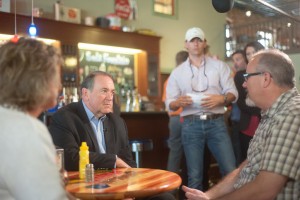 Presidential candidate Mike Huckabee (R) talks with Oskaloosa Pastor Troy Renter at Smokey Row Coffee in Oskaloosa on Wednesday.
