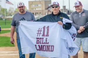 Matt Saville unfurls a flag in honor of Bill Almond and his 25 years of service to the Babe Ruth program. 