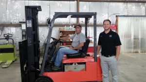 Carl Wright (warehouse assistant) on lift and Zachary McLaughlin of Hupp Toyotalift.