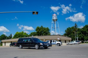 The first of 3 hearses pass through the main intersection of New Sharon on Tuesday afternoon, on their way to Union Mills Cemetery. 