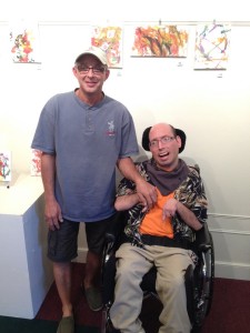 Volunteer Tony Pearson (left) and COC person supported Mike Cossolotto (right) at Mike’s exhibit at the Joan Kuyper Farver Art Gallery in the Pella Community Center