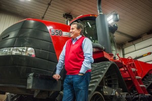 Rick Santorum leans on a tractor at the Boender farm on Monday night before addressing over 50 supporters.