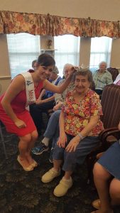 Eddyville-Blakesburg-Fremont graduate Emma Haselhuhn, Miss Heartland 2016 places her crown on Sylvan Woods Assisted Living (Ottumwa) Resident Emma Lohman.  The pageant winner played her saxophone for all the Residents at Pennsylvania Place Retirement Living, which she will play for the talent portion of the Miss Iowa pageant to be held next month in Davenport.   She also talked about her platform which is children’s literacy and answered many questions from the Residents.