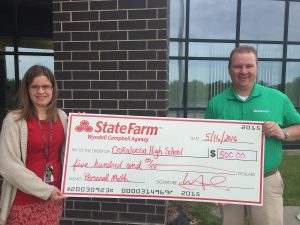 Beverly Jenkinson, High School Math teacher is presented $500 from State Farm Agent Wyndell Campbell to assist in purchasing work books for the Foundations in Personal Finance curriculum.