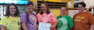 April Molyneux receives her Volunteer of Excellence Award from the Oskaloosa Girl Scout Service Team. Pictured from left are: Sandi Tucker­Stanbro, PR/Events Coordinator; Molyneux; Jessica Gladson, GSGI Girls Services Manager; Stephanie McAdoo, Service Unit Manager; and Jodie Sirovy, Product Manager. 