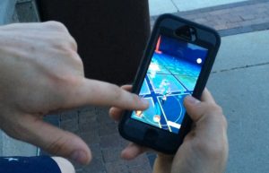 Zach Myers describes how players navigate using the Pokemon Go app. The screen is showing where the virtual Pokemon and related items are using a map of Oskaloosa as reference.