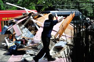 A member of Biloxi Fire throws water damaged material onto the ever growing mounds of debris that have sprung up around Baton Rouge.