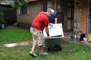 New Sharon Fire's Dustin Briggs helps get a load of soaked wood and home material to the curb in Baton Rouge.