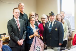 A presentation of a Quilt of Valor to Darrin Alderson for his service to our country, his leadership role as Commander of our local American Legion, and for how he cares for Veterans. The ceremony took place at Hy-Vee in Oskaloosa.  Quilt was handmade by Connie Funk from Iowa City, and presented by Charlie Funk, President & CEO of MidWestOne Bank. Pictured L to R: Clete Hjorth, Director of Oskaloosa Hy-Vee, Charlie Funk, Connie Funk, Sandy Bailey, MidWestOne Bank Market President, Amanda Mitrisin Lemke, Margaret Ratcliff, Merri Chris Hawker, Darrin Alderson, Lisa Alderson, and Ed Ed Butler. 