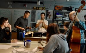 The Queen's Cartoonists, a "six cat" swing band visiting Oskaloosa High School from Queens, New York, were greeted Thursday morning by a rush of students setting up their instruments for third period, while Louis Armstrong played in the background. (photo by Andy McGuire)