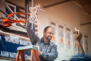 William Penn University Mens Basketball Coach John Henry holds the net in celebration as his team wrapped up their second consecutive conference title this month.