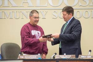 Former Oskaloosa School Board member and president Tom Richardson receives a plaque recognizing his years of service to the district.