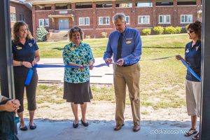 Marsha Riordan (left center) and John Ottosson (right center) cut the ribbon for the newly established P on the campus of William Penn.