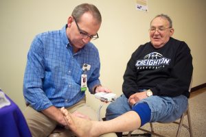 Dr. Beers checks blood flow in Elmer Stahl's legs at a free screening during Saturday's Diabetes Fair inside Penn Central Mall.