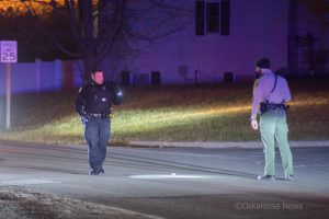 Oskaloosa Police Officer Nick Landgrebe (left) investigates the scene where parties reported shots were fired at the intersection of Green Street and Pella Avenue in Oskaloosa.