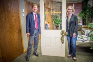 Eric Palmer (left) and Oskaloosa Chamber Director Ann Smith (right) pose with the door found during renovations.