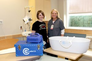 Shown with the CuddleCot™ are Be Still and Know Founder Kendra Nicholson (left) and Mahaska Health Partnership Birthing Center Director Heather Cook (right)