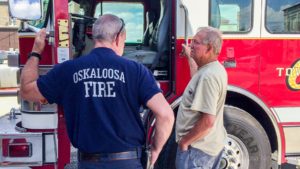 Oskaloosa Fire Chief Mark Neff talks with former Oskaloosa Fire Chief Frank Glandon about the aerial apparatus that was just delivered to firefighters in Oskaloosa.