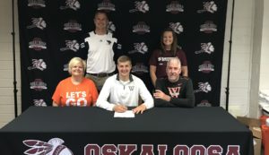 Jaden Van Roekel (center) signs with Wartburg Football. His mom Wendy (left) and father (Scott) right, along with OHS Head Football Coach Jake Jenkins (back left)