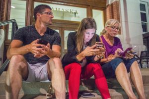 Holly Brink (center) and her family work their phones to get the latest returns during Tuesday's primary election.