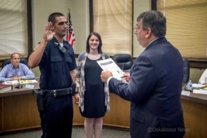 Justin DeKleine (left) was sworn is as Oskaloosa's newest police officer on Monday. Oskaloosa Mayor Dave Krutzfeldt (right) administered the oath of office. DeKleine wife, Makayla (center) pinned on her husband's badge.