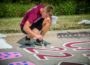 Casey Hill paints his number on 'Indian Trail' to start his senior year at Oskaloosa High School.
