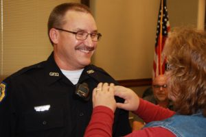 Oskaloosa's newest police officer, James Arment has his badge pinned on him by his wife during Monday's city council meeting. (Oskaloosa Police Department Photo)