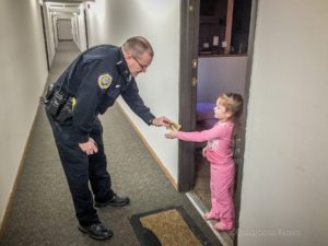 Oskaloosa Police Officer Jim Arment gives a young girl a sticker on New Years Eve.