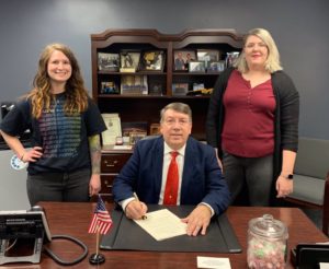 Mayor David Krutzfeldt (center) signs the proclamation for Sexual Assault Awareness Month on Thursday, March 21. He is joined by Crisis Intervention Services Sexual Assault Advocate Hailey Brown (left) and Sexual Assault Prevention Specialist Erin Weber (right).