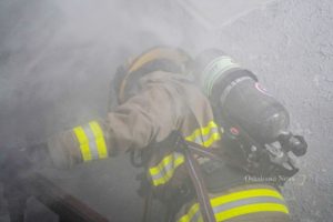 An Oskaloosa firefighter enters a home filled with theatrical smoke during a recent training exercise.