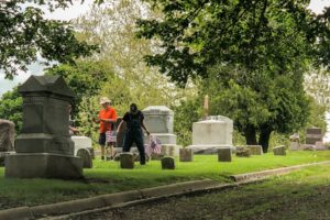Volunteers place flags at Forest Cemetery in preparation for Memorial Day.
