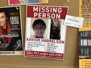 Xavior Harrelson Missing Person Poster hanging in a downtown Montezuma business.