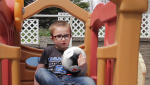 Kaitlin Lang / Special for IowaWatch Will Clark, 5, plays outside at his Oxford, Iowa, home. Will, a preschool student, who is among several children on the autism spectrum, had difficulty adapting to online learning during the COVID pandemic. 