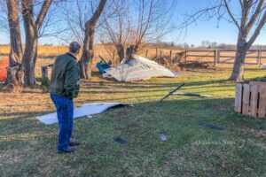 Rural Mahaska County resident Kenneth Mortensen survey's what's left of his roof that was blown off during a derecho on Wednesday evening.