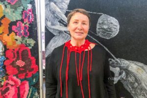 IraVish stands near her artwork in front of Envision Art Gallery in Oskaloosa, Iowa.