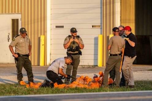 Investigators examine the homemade explosive device after it was made safe by the Iowa Fire Marshal's Office bomb squad.