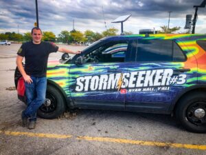 Brandon Copic next to his storm chase vehicle as he staged for severe weather in Oskaloosa, Iowa.